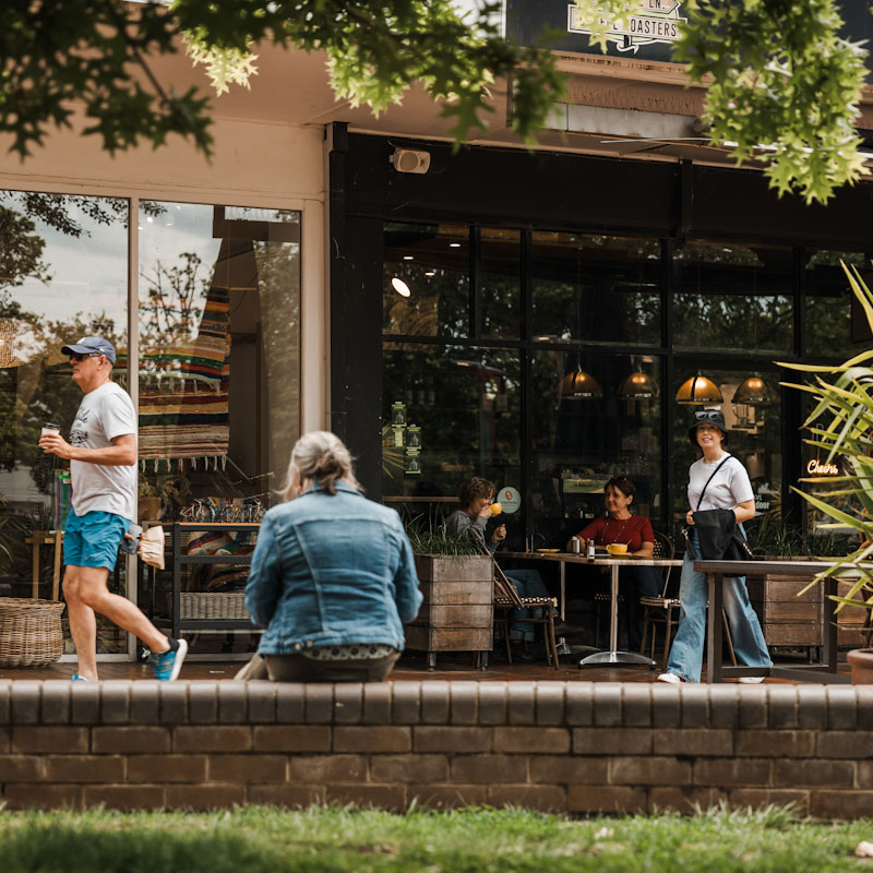 People in Kingtson walking and drinking coffee